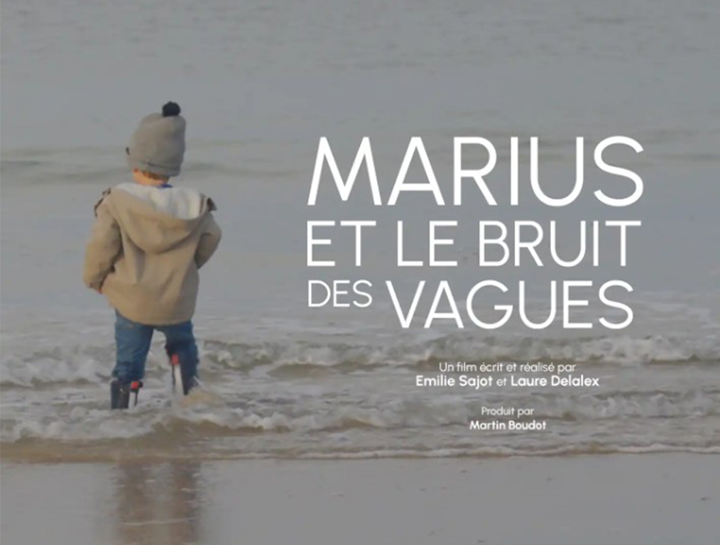 Extrait de l'affiche du film Marius et le bruit des vagues. On y aperçoit Marius de dos, les pieds dans l'eau face à la mer.